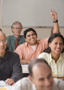 adult student smiling and raising hand to answer question 