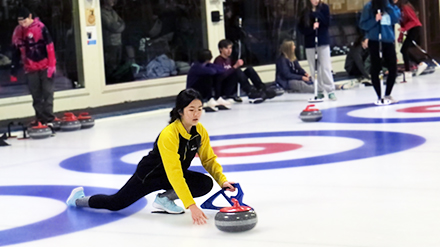 A female student prepares to play curling