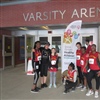 Heydon Park SC students and staff standing next to Special Olympics’ flag at Varsity Arena