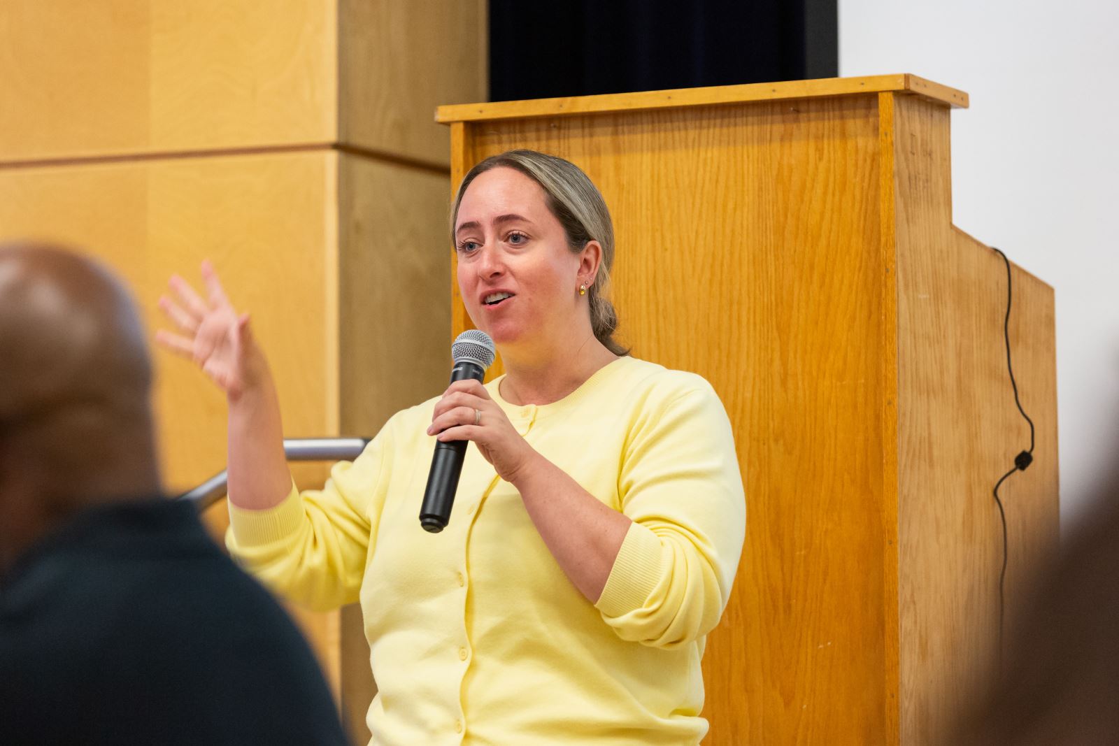 Photo of Zoya speaking in a gynasium to staff.