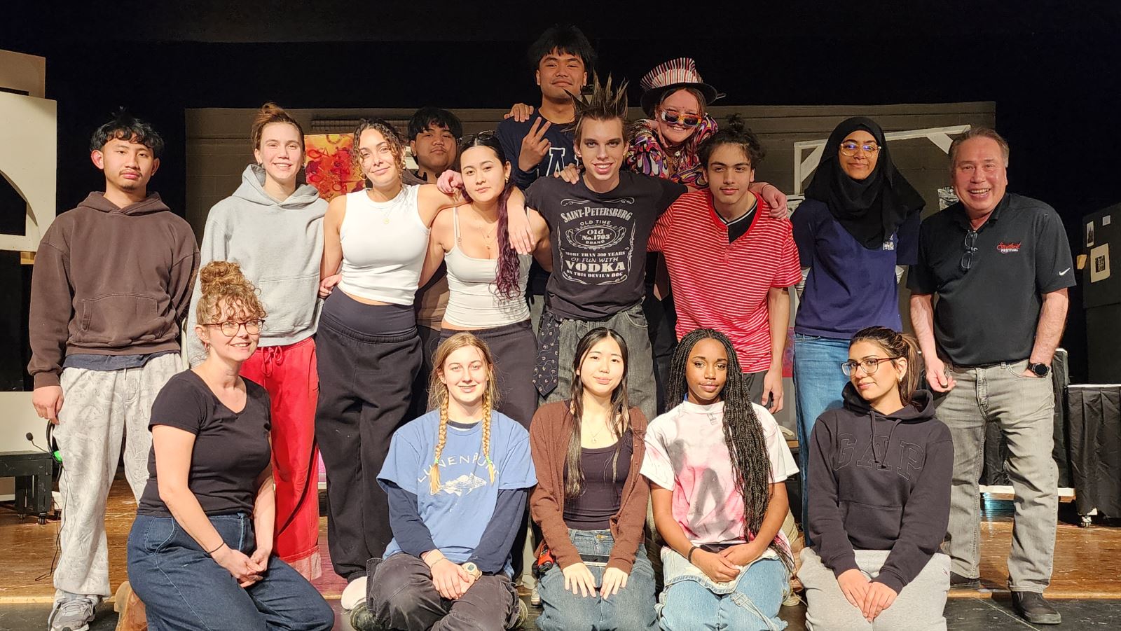 Group of students and staff pose together on stage after a theatre performance, representing the cast and crew involved in the production.
