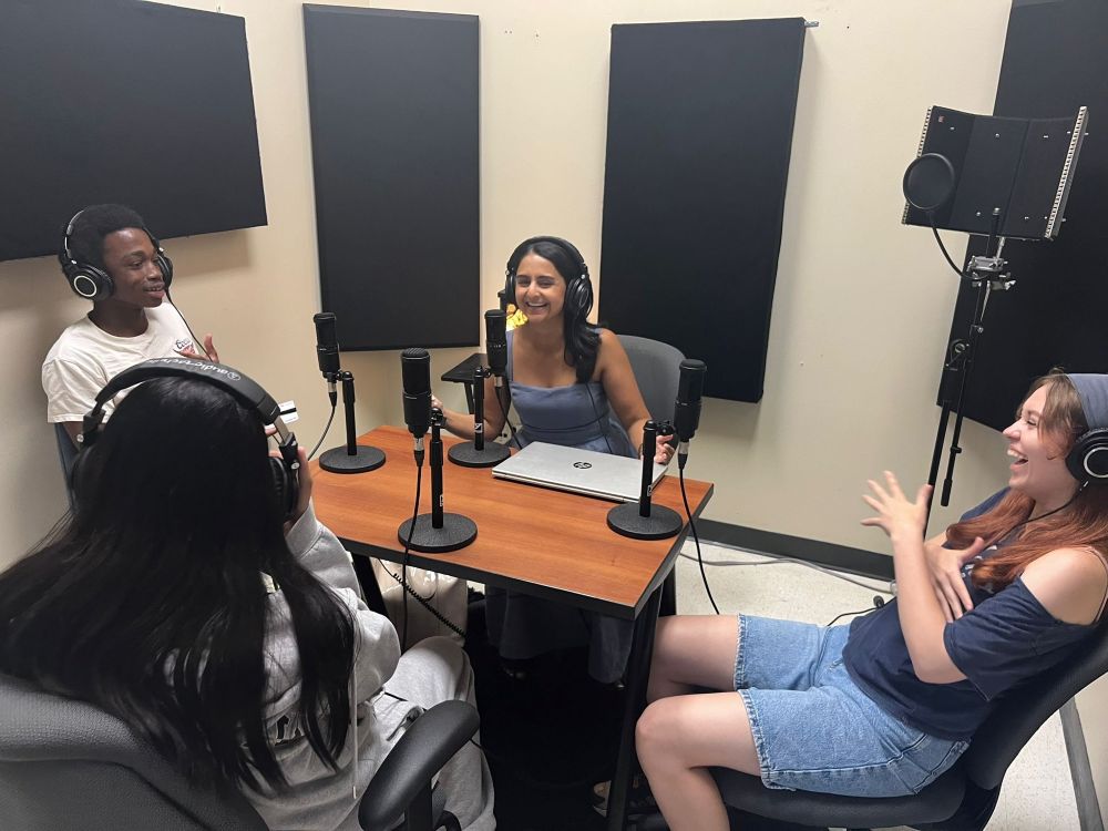 Students gather around a table at the recording studio at the Bickford Education Centre as they record an episode of the 4Students podcast.