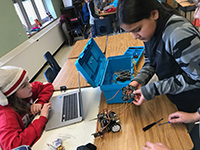Two students working collaboratively building a robot