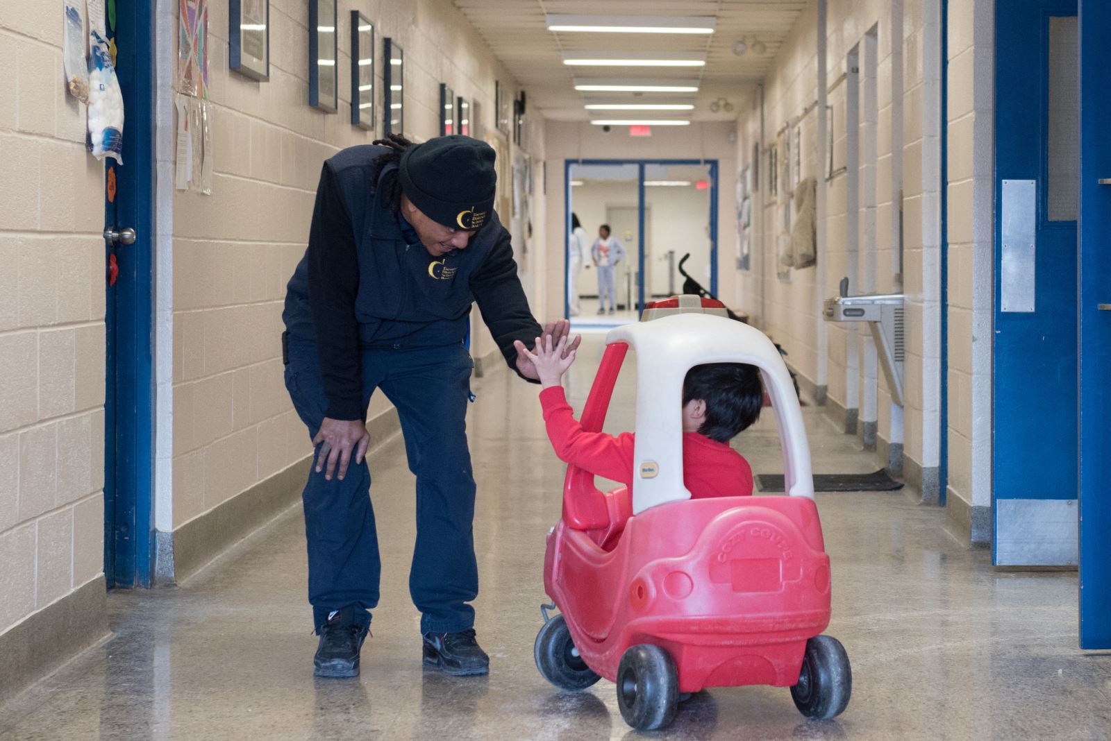 Photo of Keelon giving a high-five to a student.