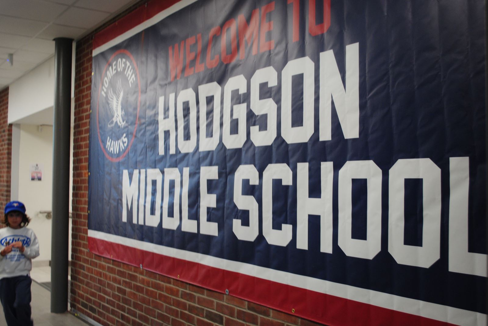 A large sign on a wall reads "Home of the Hawks: Hodgson Middle School"