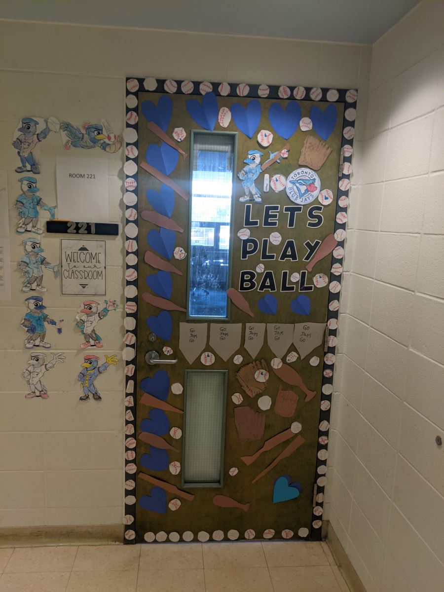 A school classroom door decorated with blue hearts, Blue Jays logos and "Let's Play Ball"