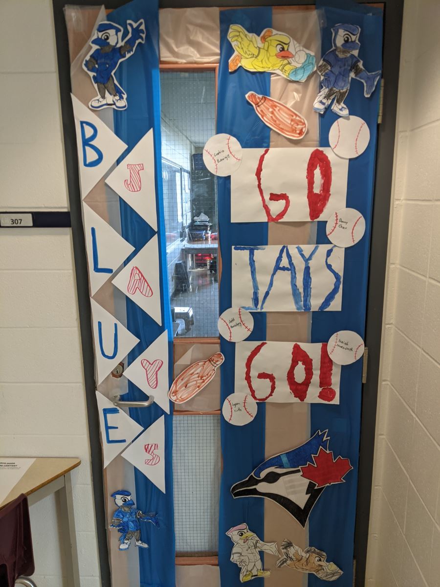A school classroom door decorated with "Go Blue Jays" in children's writing and baseball cut outs
