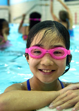 Elementary school child smiling in a swimming pool