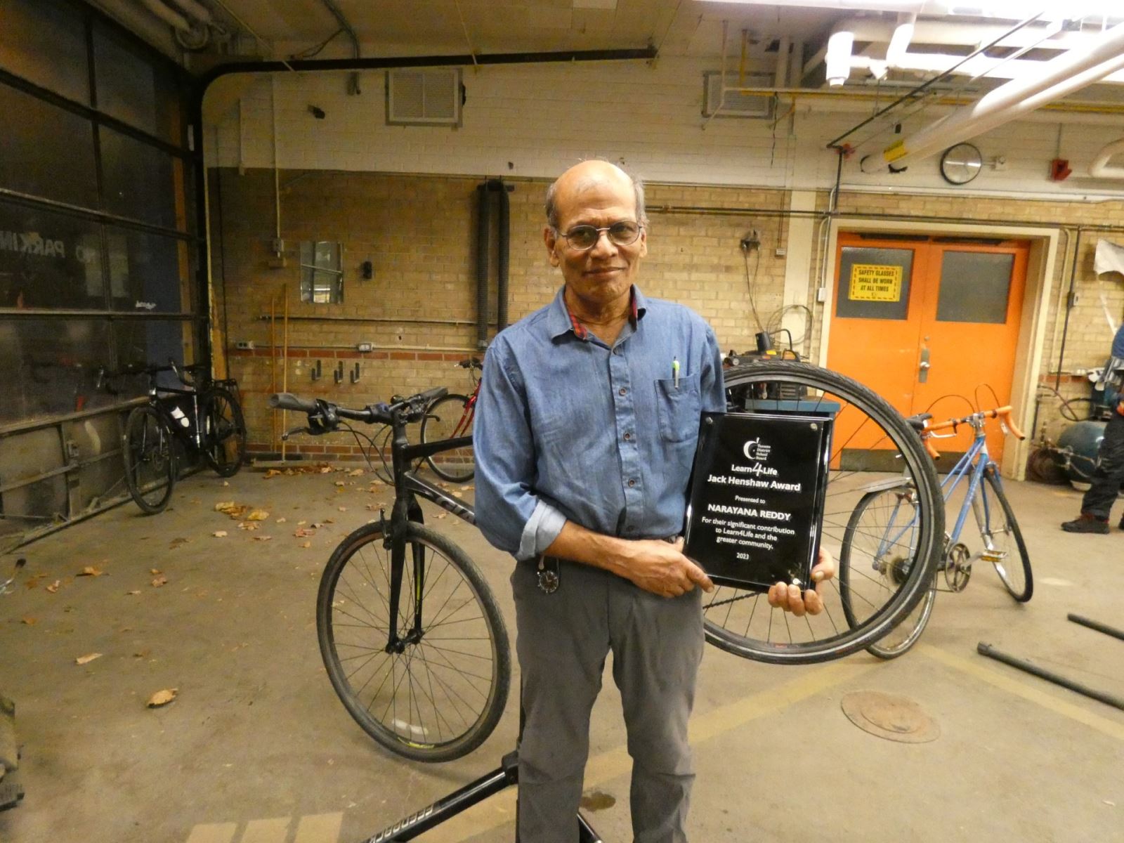 2023 Jack Henshaw Award Winner Narayana Reddy holding a plaque commemorating his award