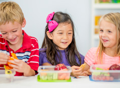 Three content children enjoying their lunches