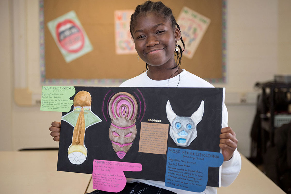 Student holding up art work