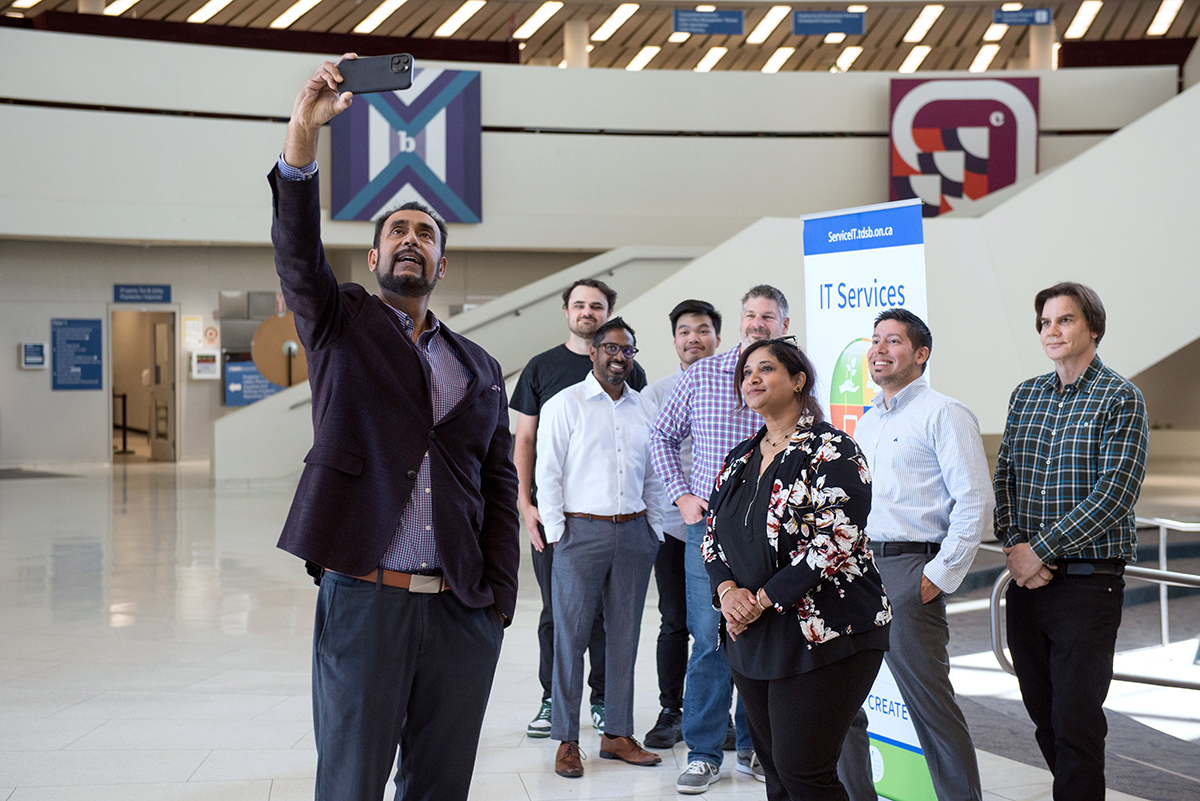 Group of staff taking group selfie