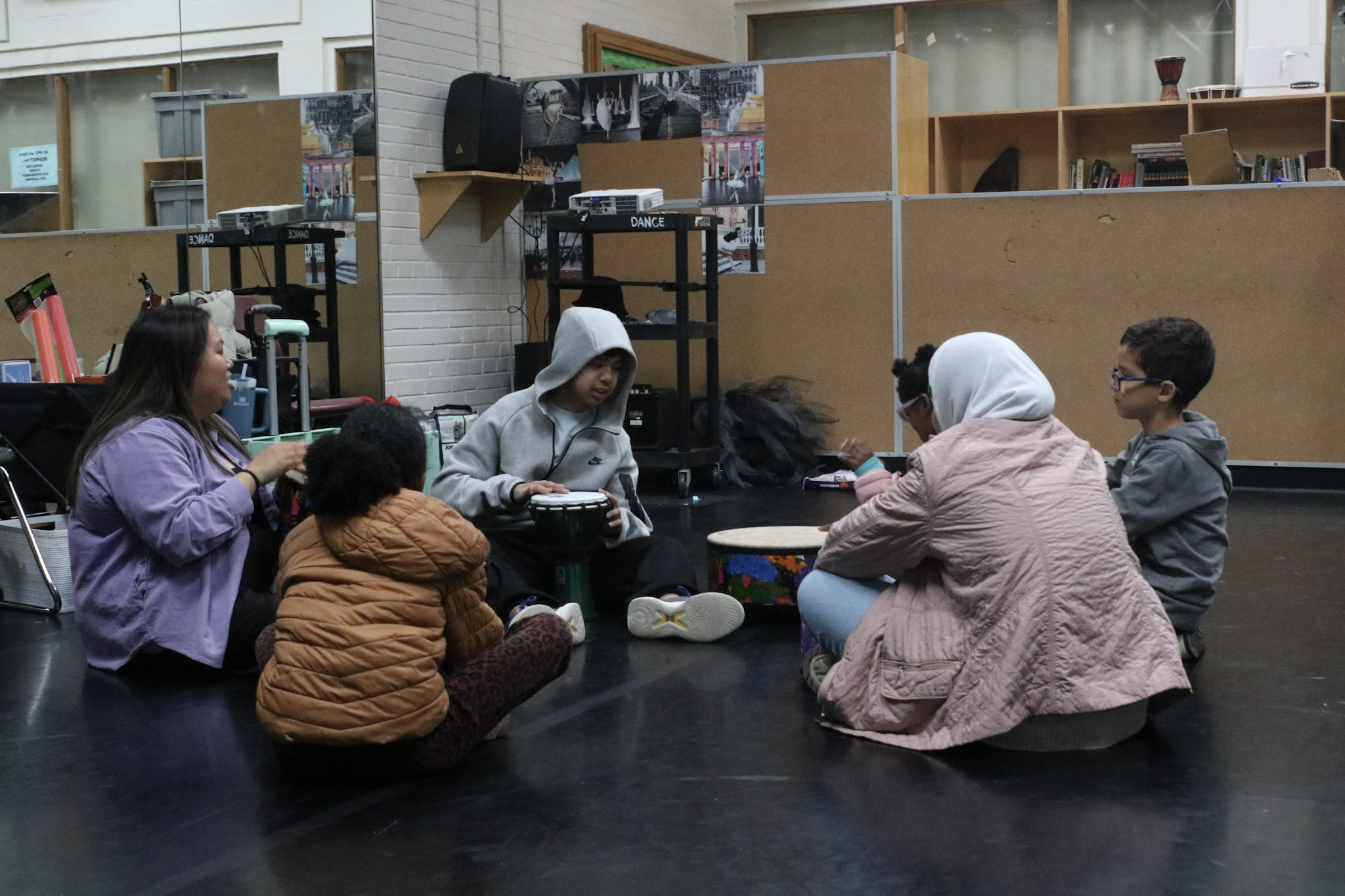 Group of students and parents sitting in circle on carpet
