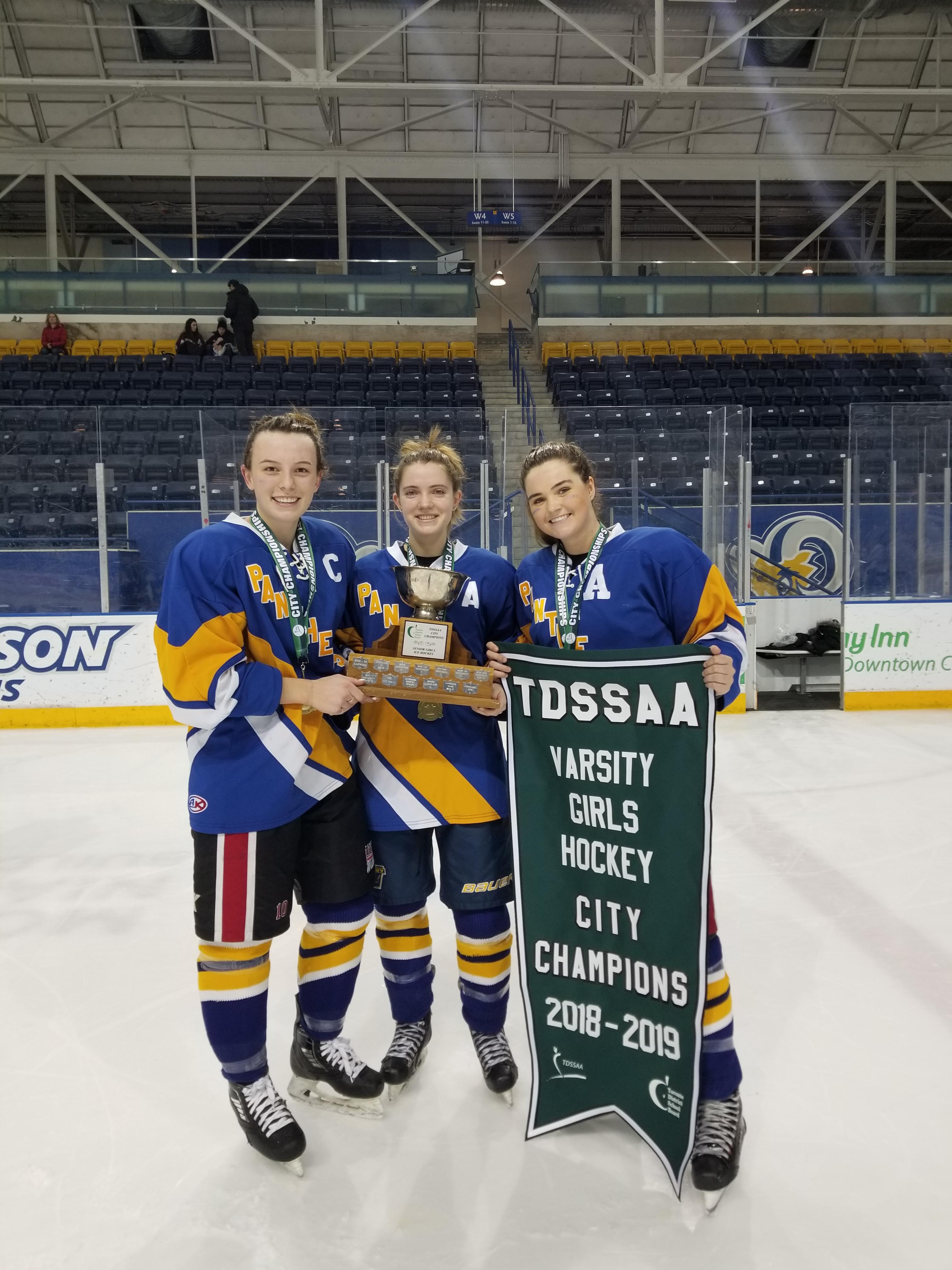 Three girls in hockey uniforms